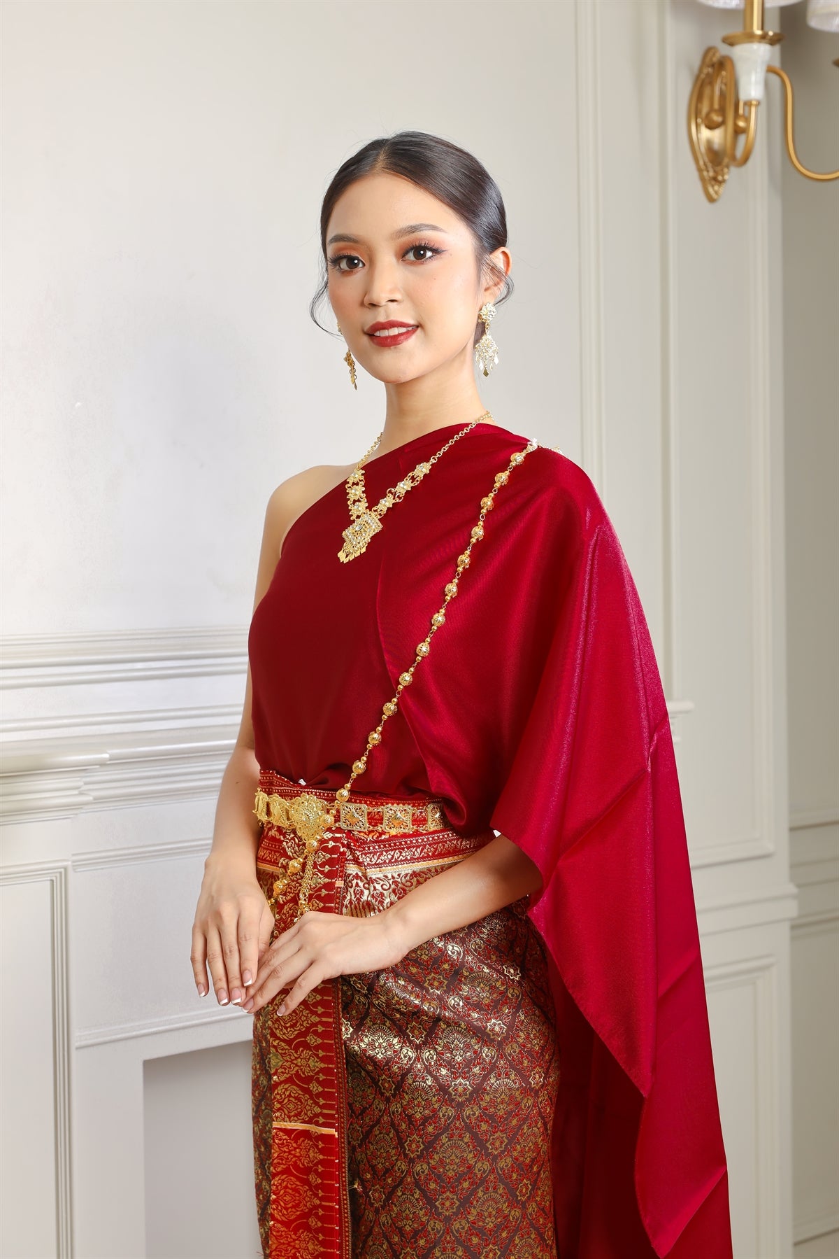 A woman wearing our red traditional Thai dress.
