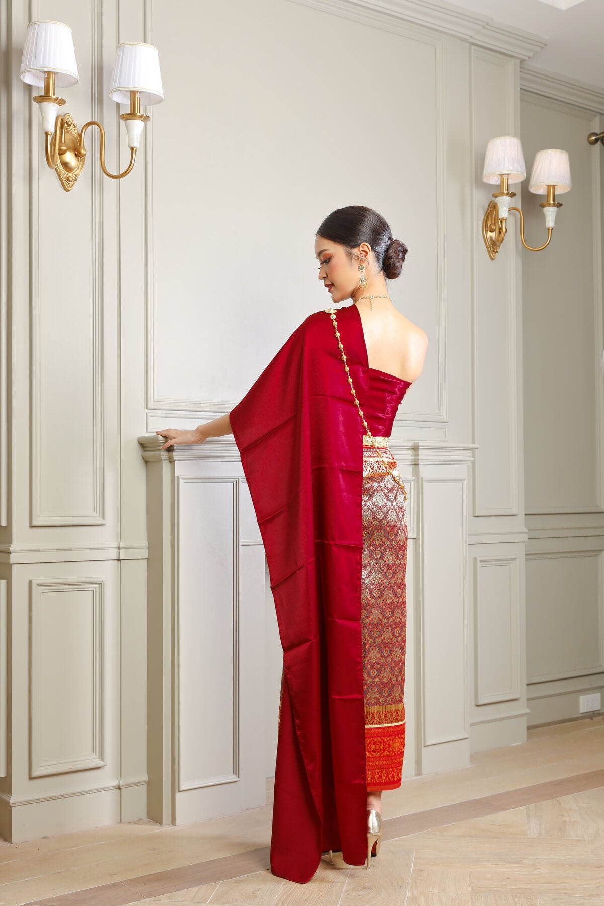 A ruby red traditional Thai outfit worn by a Thai woman.