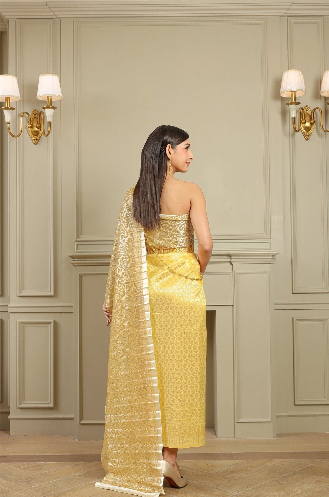A woman dressed in gold traditional Thai clothing on her wedding day.